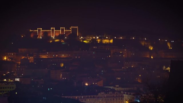 Saint George Moorish castle occupying a hilltop overlooking the center of Lisbon and Tagus River. Night illuminations during Christmas holiday season