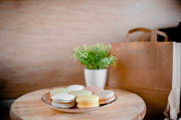 Kitchen plate with colorful macaroon. Wooden table