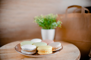 Kitchen plate with colorful macaroon. Wooden table