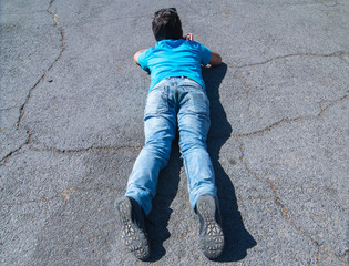 Boy lying on ground.
