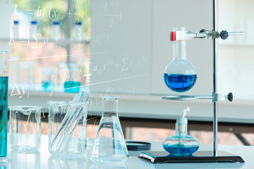 Laboratory chemical material with representation of Physical formula and Chemistry science fomula and structures in the background. Research and development concept.