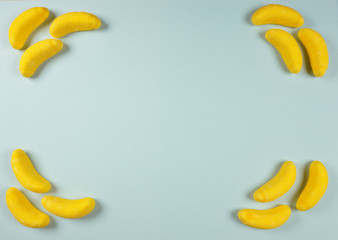 Candy background of yellow banana on blue background