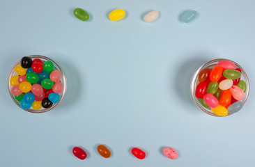 Sweets and candy colorful jelly beans in glass at a blue background