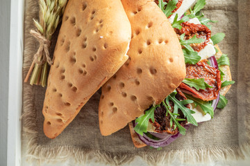 Homemade sandwich with arugula, dried tomatoes and cheese