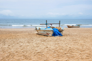 blue fishing boat on empty beach in Sri Lanka 