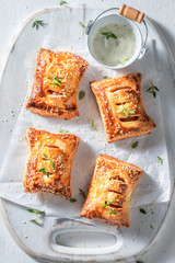 Hot sausage in puff pastry with tatar sauce and herbs