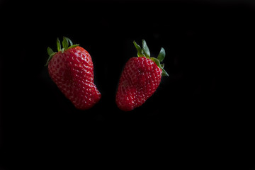 Fresh strawberries on a black background. Horizontal orientation