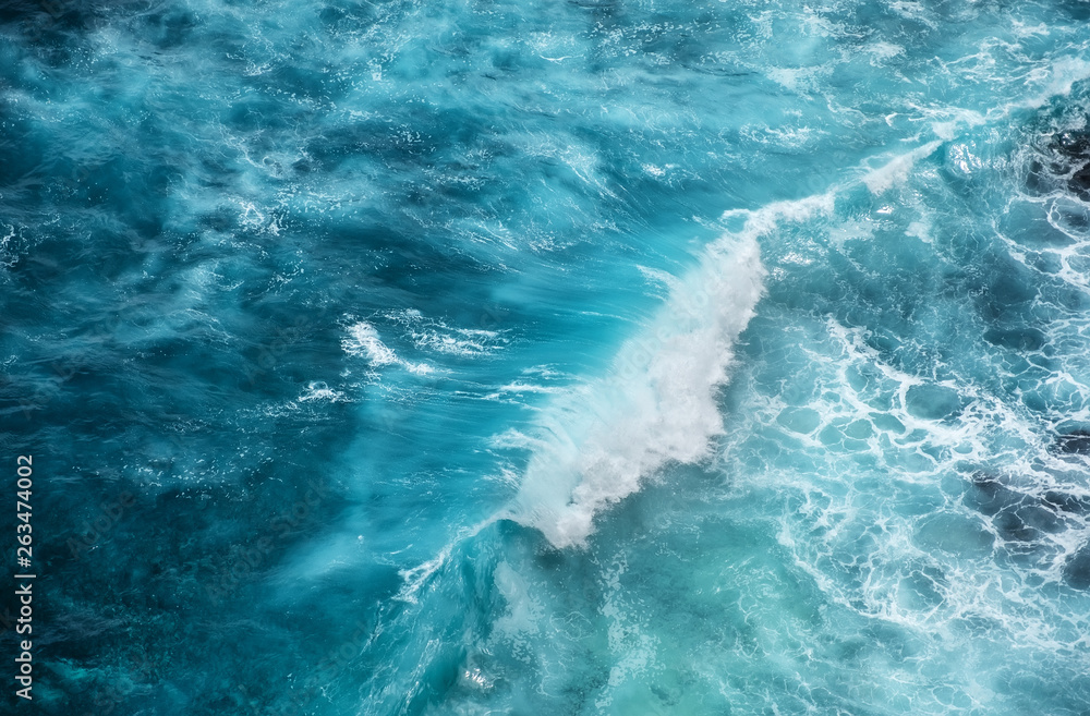 Wall mural waves and azure water as a background. view from high rock at the ocean surface. natural summer seas