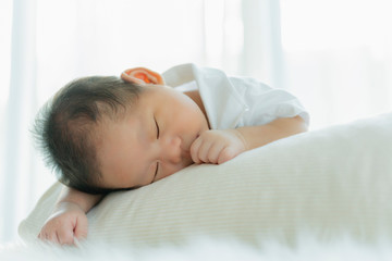Obraz na płótnie Canvas cute infant baby boy sleep with sweet dream and peaceful white soft bed