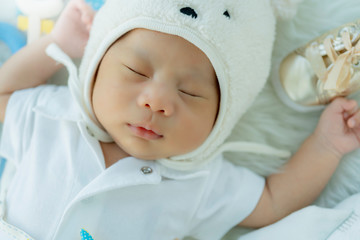 Fototapeta na wymiar cute infant baby boy sleep with sweet dream and peaceful white soft bed