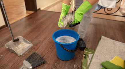 The girl washes the floor with a rag in the room