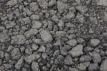 gray stone texture of asphalt pieces with cracks on the road
