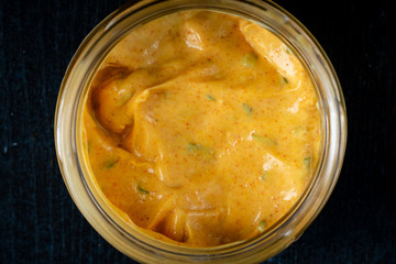 Homemade organic Dijon mustard on a dark wooden background, souce for meat dishes, top view