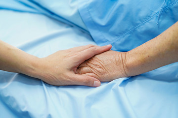 Holding Touching hands Asian senior or elderly old lady woman patient with love, care, helping, encourage and empathy at nursing hospital ward : healthy strong medical concept.