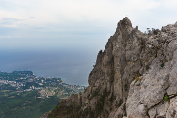 Fototapeta na wymiar High stone teeth of the AI-Petri mountain with a height of 1234 meters above sea level rises above the Crimean coast