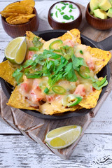 Nachos with cheese, chicken, greenery and vegetables. Mexican cuisine appetizer