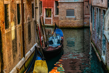 Fototapeta na wymiar Beautiful morning view of a narrow street canal with a gondola between old houses in Venice, Italy