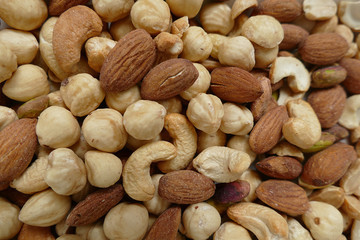 nuts, cashew nuts, dry almonds all close up on a plate, dry foods on black ground, nuts, nuts, peeled hazelnuts, cashews and almonds, stand together,