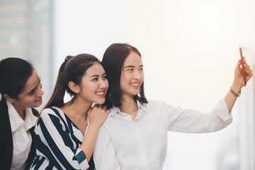 Asian lifestyle businesswoman best friends smiling and having fun walking selfie at the city