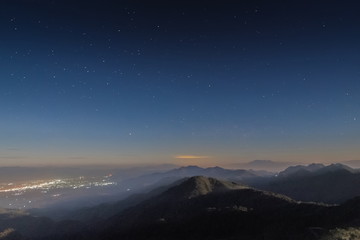 Mountain view of the road, city and top hill under the stars, Top view point of Doi Ang Khang at night, Chiang Mai, northern of Thailand.