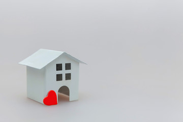 Simply minimal design with miniature white toy house and red heart isolated on white background. Mortgage property insurance dream home concept. Copy space