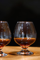 Two goblets of brandy on wooden old counter top