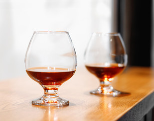 Two goblets of brandy on wooden old counter top