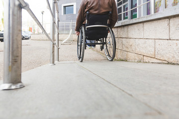 Man in a wheelchair use a wheelchair ramp.