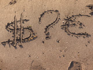 Signs on a sand, dollar sign question mark and euro sign. Concept which one to choose for investment.