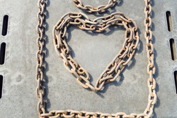 Fototapeta na wymiar Rusty chain in the shape of a heart, symbolizing love.