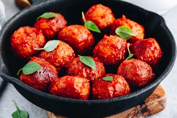 Homemade beef or chicken meatballs in tomato sauce in a frying pan