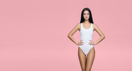 Fototapeta na wymiar Fit and sporty girl in underwear. Beautiful and healthy woman posing in white swimsuit. Slim body. Sport, fitness, diet, weight loss and healthcare concept.
