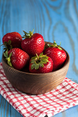 Fresh natural strawberries in wooden bowl. Healthy vegan food concept. Summer eco fruits and vegetables.
