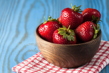 Fresh natural strawberries in wooden bowl. Healthy vegan food concept. Summer eco fruits and vegetables.