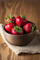 Fresh natural strawberries in wooden bowl. Healthy vegan food concept. Summer eco fruits and vegetables.
