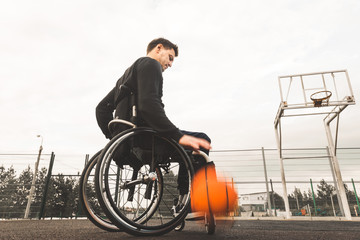 Young man in a wheelchair playing basketball.