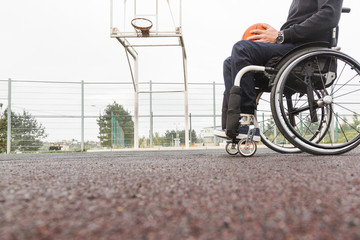 Young man in a wheelchair playing basketball.