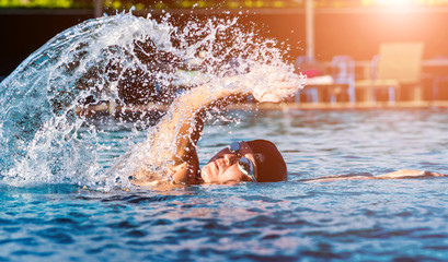 Young athletic man swimming in the swimming pool