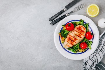 Grilled salmon steak and baked vegetables. Tomato, broccoli, zucchini with salmon fillet. Top view