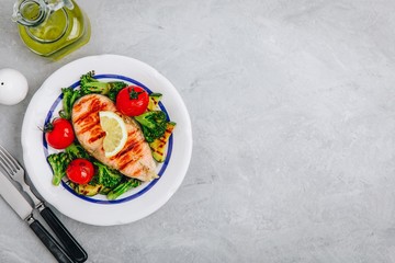 Grilled salmon steak and baked vegetables. Tomato, broccoli, zucchini with salmon fillet. Top view