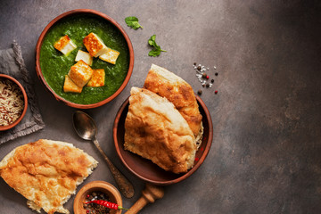 Palak Paneer Indian food, naan bread, rice and spices on a dark background. Top view, flat lay, copy space