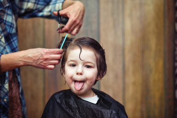 A little boy is trimmed in the hairdresser's