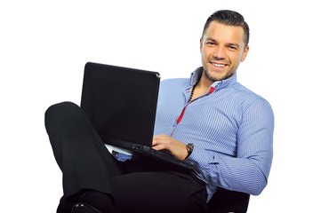 Young businessman sitting at studio with laptop computer isolated on white