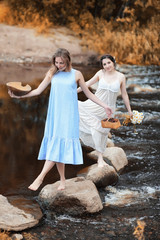 Girls in dresses in autumn on the river