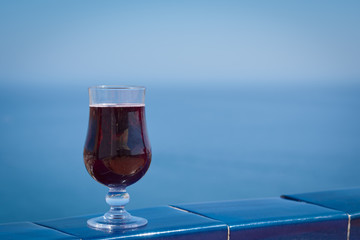 The glass of wine against the picturesque sea view illustrating the holiday and relax atmosphere.