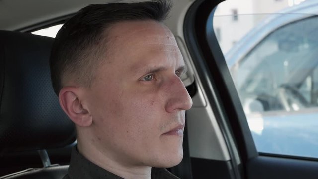 Portrait of a man sitting in a car. He shakes his head questioningly.