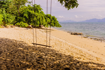 An empty simple wooden swing on tropical beach, Thailand