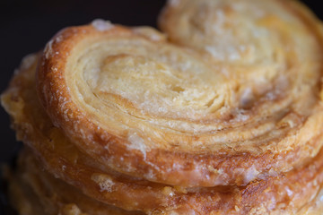 Elephant Ears cookies with sugar on the table. Palmiers pastry background.Close up.