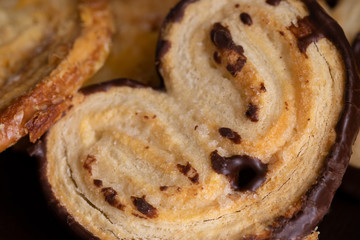 Chocolate Elephant Ears cokies on the table. Palmiers pastry background.Close up.