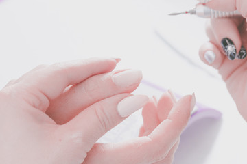 The hands of the master of manicure and the hands of the client close-up during the nail design...